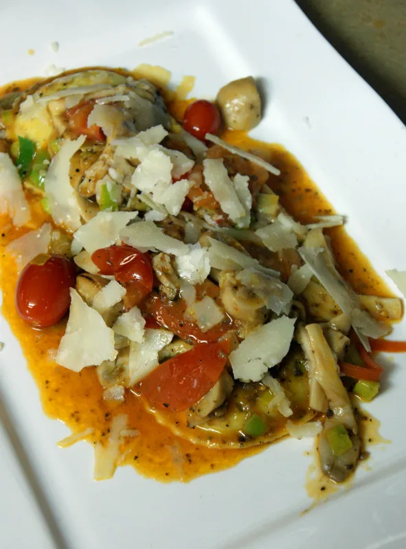 Ravioli met champignons, kerstomaatjes en parmezaanschilfers in tomaten-botersaus